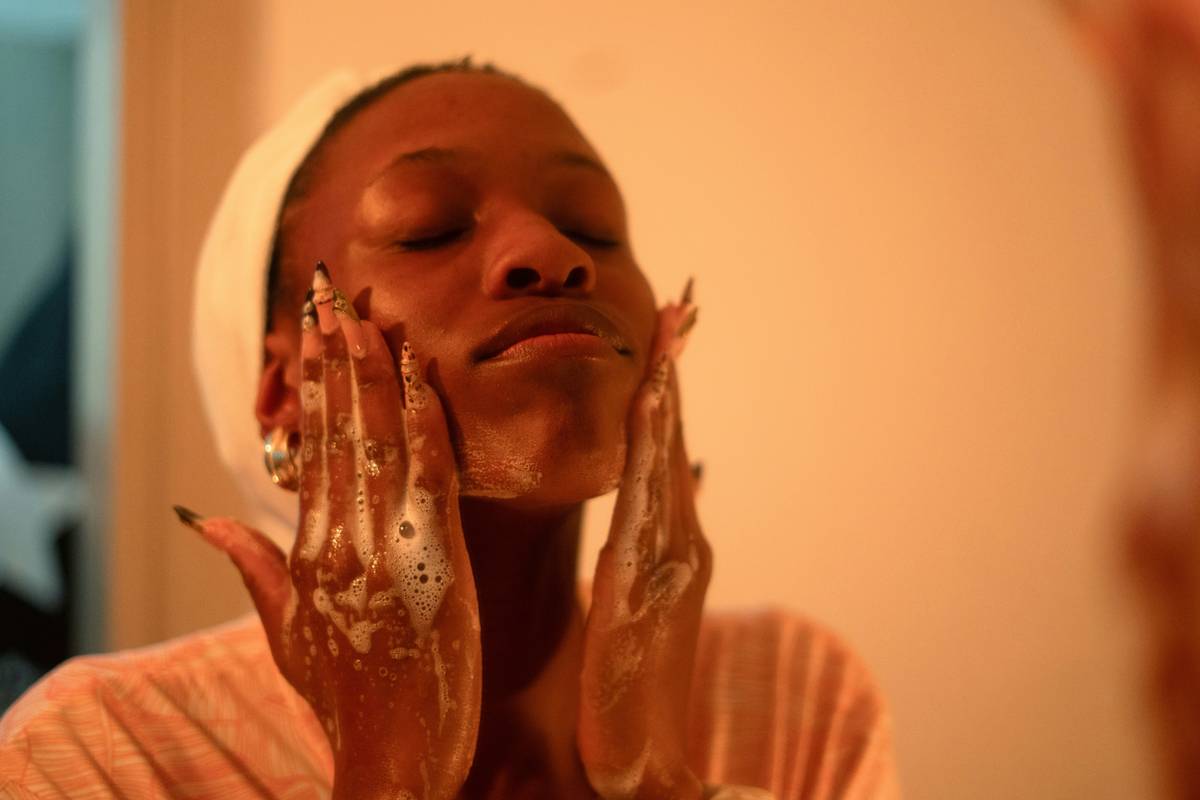 Woman performing dry brushing for skin with natural bristle brush on legs