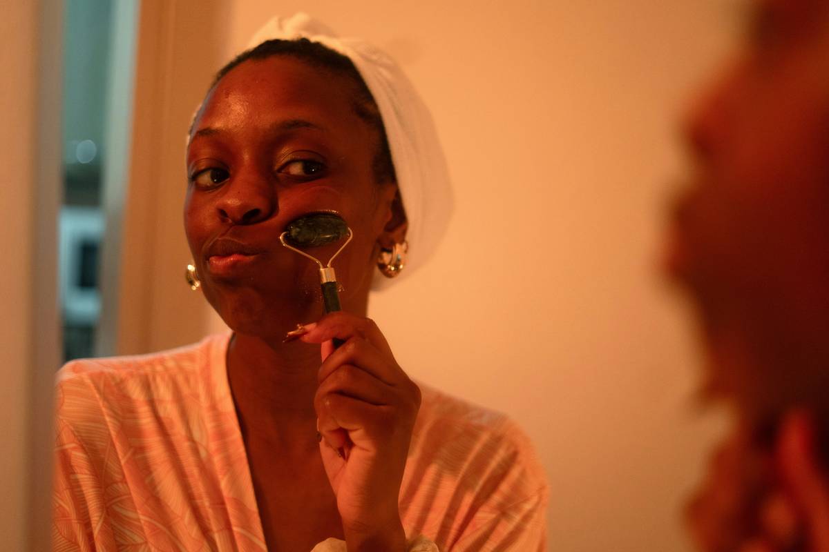 Woman performing full body dry brush exfoliation with natural bristle brush toward heart direction