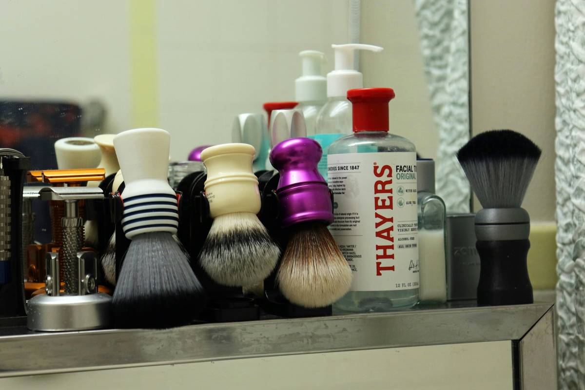 Woman using stiff-bristled brushes for dry brushing skin toward lymph nodes