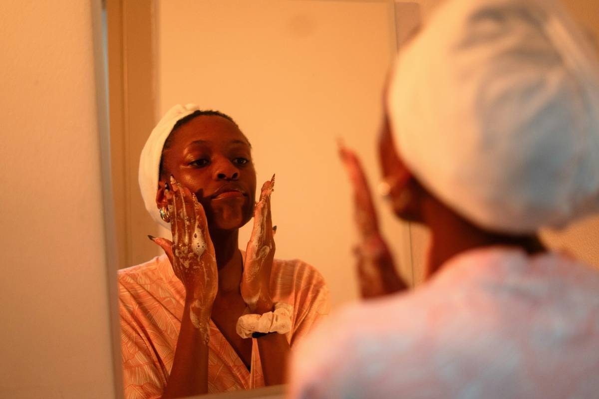 Woman gently dry brushing for face with soft-bristle tool near cheekbone